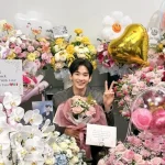 2026년 8월 활동 재개 후 꽃다발을 들고 미소 짓는 김수현