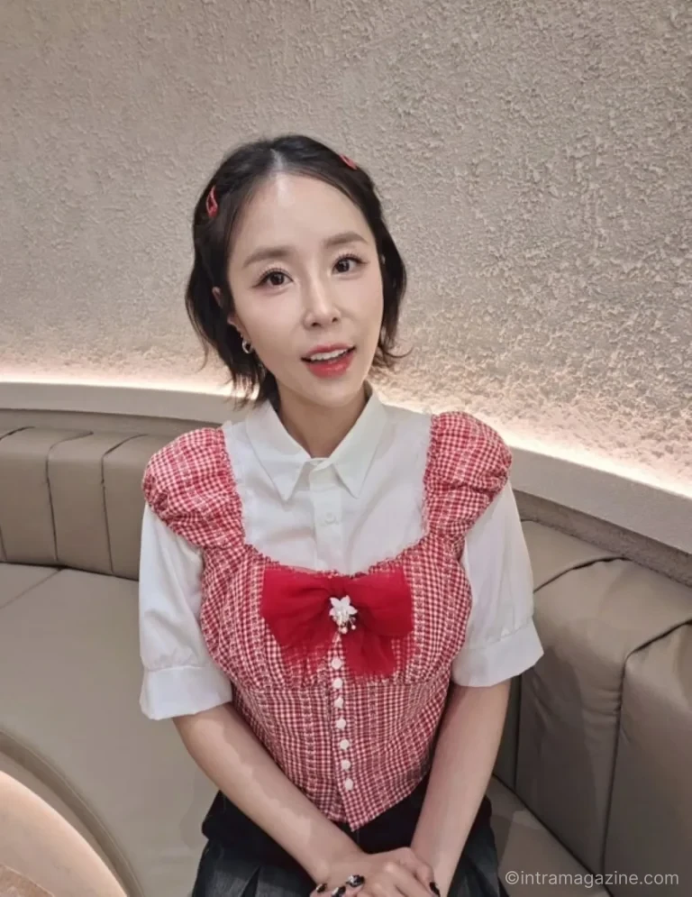 코요태 신지가 레드 체크 상의와 리본 스타일링으로 미소 짓는 모습