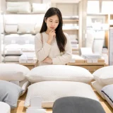 다양한 종류의 베개 앞에서 올바른 베개 높이를 고민하는 사람