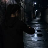 어두운 골목길에 홀로 서 있는 여성의 뒷모습