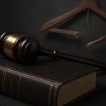 법원 판결을 상징하는 의사봉과 법전, 배경으로 부서진 바지걸이가 놓여있는 일러스트