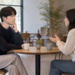 대화 상대방의 질문에 대답 대신 무표정한 얼굴로 상대를 바라보는 청년의 모습