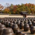 경복궁 장고 마당에 가지런히 늘어선 전통 장독대 항아리들과 가을 궁궐 기와 담장 전경