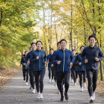 가을 숲길 코스를 무리지어 달리는 기부 마라톤 참가자들의 뒷모습