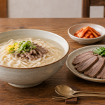진한 소고기 육수 칼국수와 정갈하게 담겨 나온 수육 한 상
