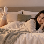 침대 위에서 편안한 면 소재 수면 양말을 신고 휴식을 취하는 발의 모습