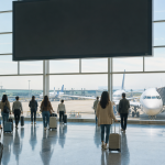 국제공항 대형 안내 전광판과 이동하는 여행객들의 모습